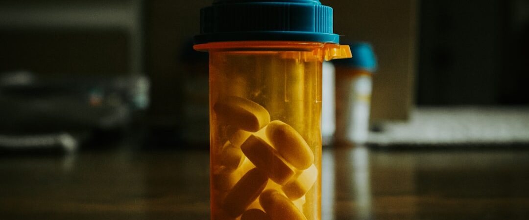 A prescription bottle filled with yellow pills on a wooden table.
