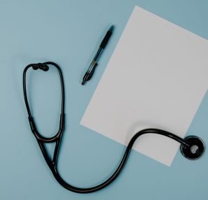 Flat lay of stethoscope, blank paper, and pen on blue surface — Amazing Subjects You Will See In The Nursing Career