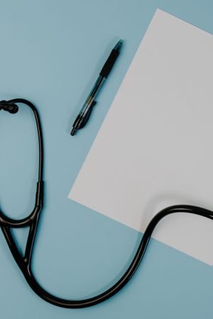 Flat lay of stethoscope, blank paper, and pen on blue surface — Amazing Subjects You Will See In The Nursing Career