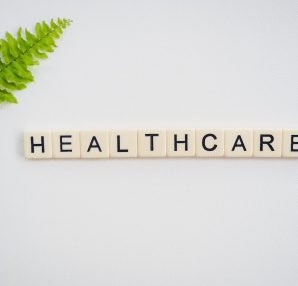 Healthcare word spelled with Scrabble tiles next to a green fern leaf on a white background. — Best Way To Test Your Sexual H
