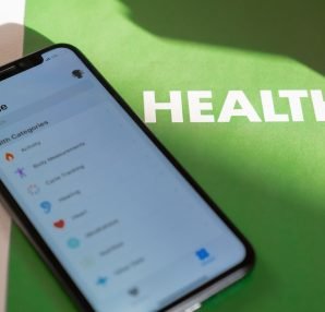 Close-up of a smartphone displaying a health app on a green surface with 'HEALTH' text. — CBD Vape Juice Health Benefits And