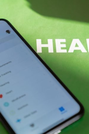 Close-up of a smartphone displaying a health app on a green surface with 'HEALTH' text. — CBD Vape Juice Health Benefits And
