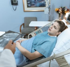 Caucasian woman in hospital bed receiving care from healthcare professional. — Fighting Weight Gain After Pregnancy Like Tess