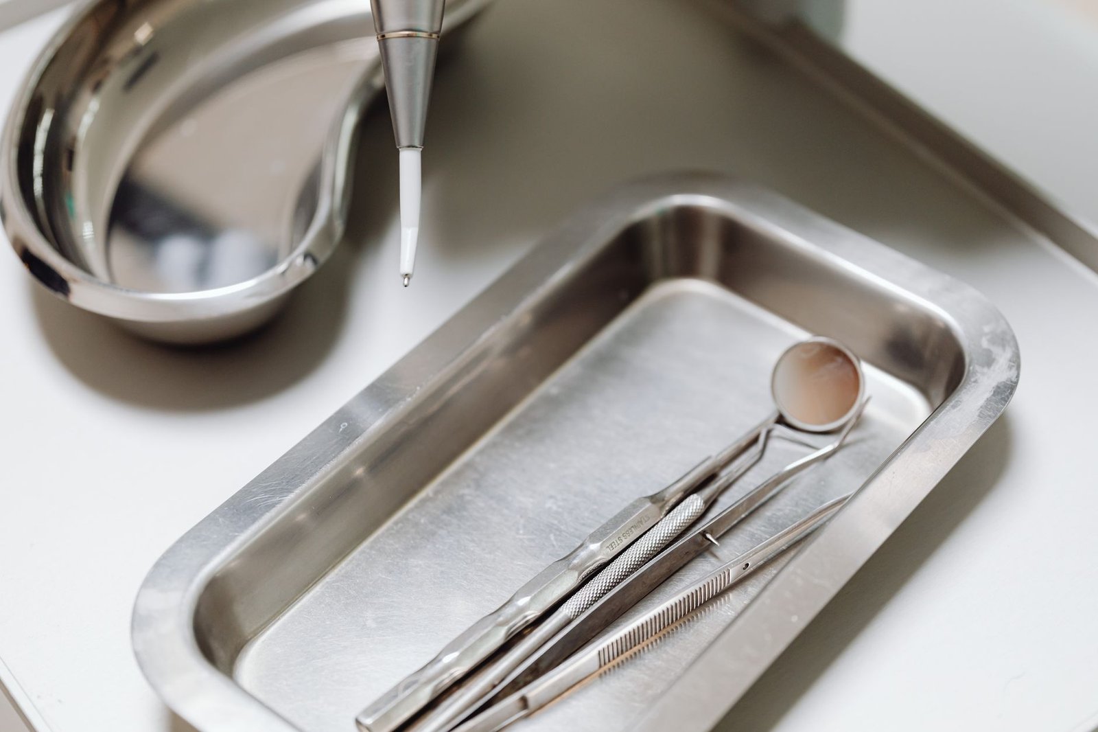 Close-up of dental tools on a clean, sterile metal tray, emphasizing hygiene and precision. — Health Care Reform - How Are Yo