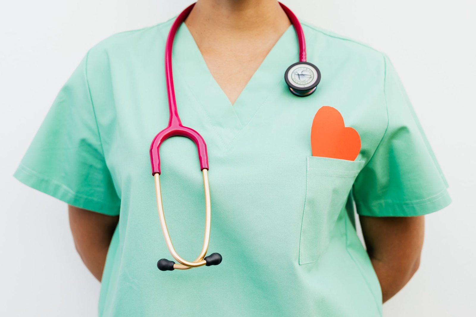 Close-up of a medical professional with a stethoscope and a paper heart cutout on a green uniform pocket. — Importance of Pre