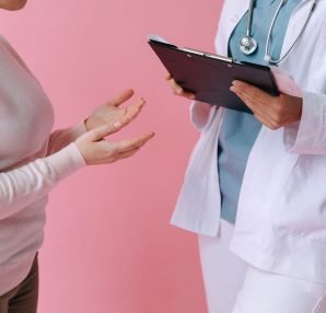 Close-up of a patient consulting a doctor with a clipboard in a medical setting. — Reasons Why to Hire Personal Trainer for T