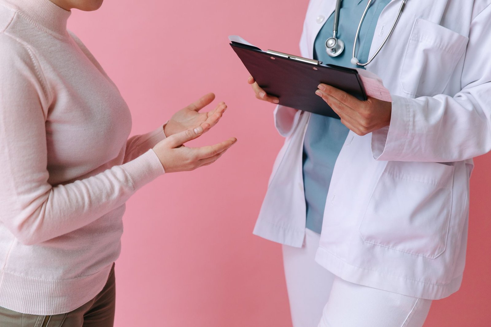 Close-up of a patient consulting a doctor with a clipboard in a medical setting. — Reasons Why to Hire Personal Trainer for T