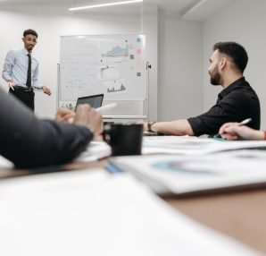 Corporate team during a presentation in an office setting, featuring discussions and planning. — Room Alba Jobs: Flexible Par