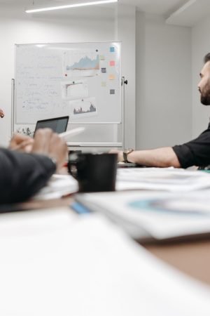 Corporate team during a presentation in an office setting, featuring discussions and planning. — Room Alba Jobs: Flexible Par