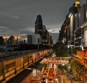 Cityscape at twilight showing busy traffic, skyscrapers, and an elevated train line in an urban setting. — What It's Like to
