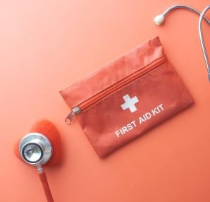 Medical tools including a stethoscope and first aid kit on a pink surface, perfect for healthcare themes. — What You Know Abo
