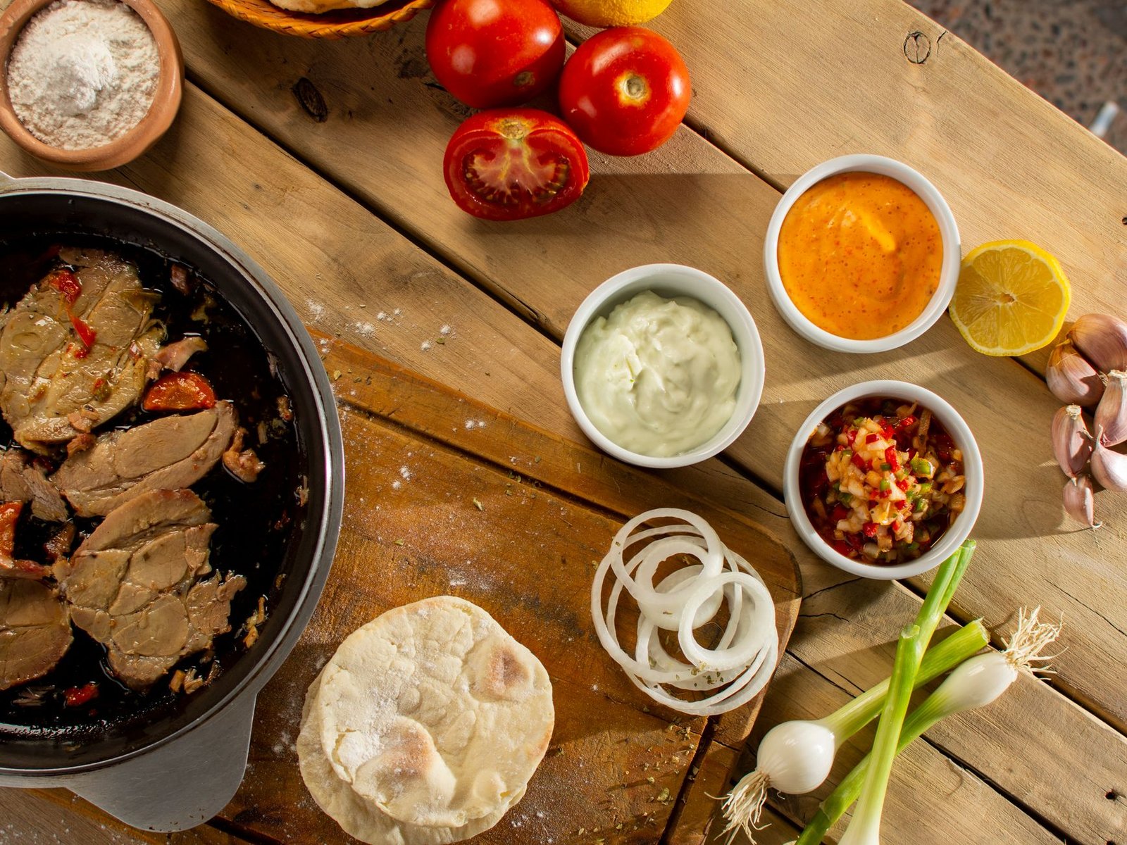 Aerial view of a kitchen table with ingredients, sauces, and cooked meat for a meal preparation. — Why Buy Organic Foods, and