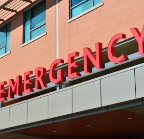 Close-up of a modern hospital emergency room entrance with prominent red letters. — Why is Onsite TB Testing Done?