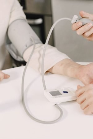 Close-up of blood pressure measurement at home highlighting healthcare equipment. — Why you might need a facelift surgery?